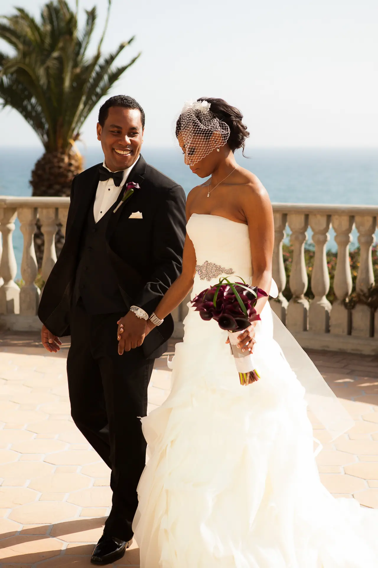 A bride and groom together by the coast on their wedding day